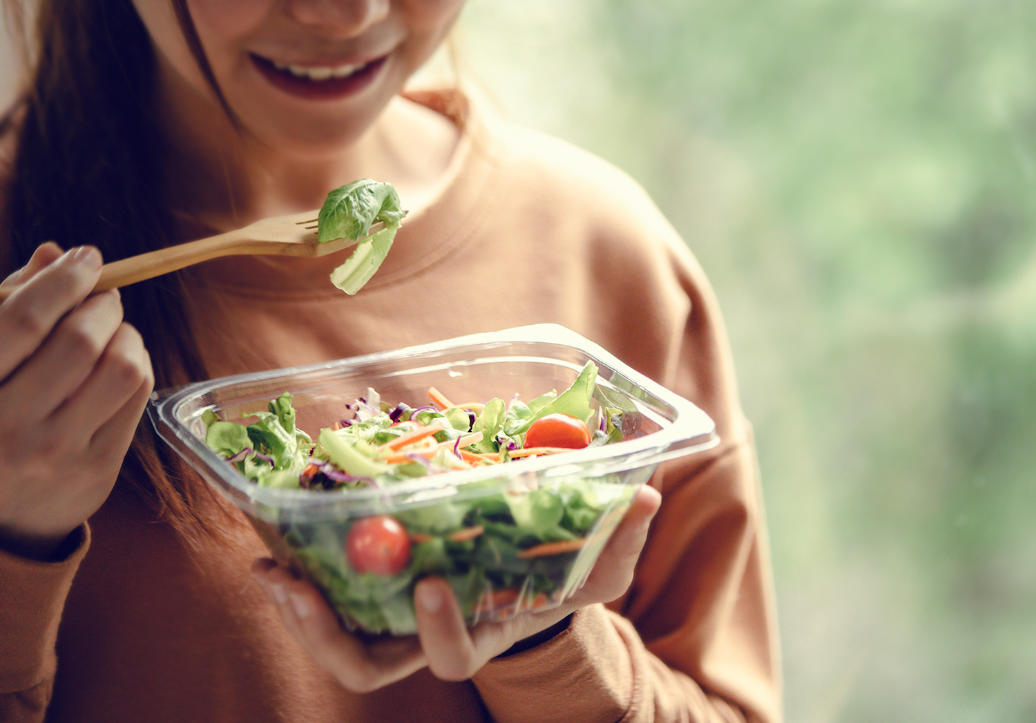 Closeup woman eating healthy food salad
